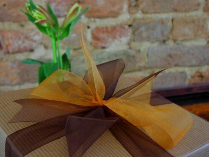 Large gift box featuring a brown ribbon with gold accent