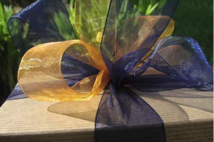 This large gift tower features kraft boxes with a blue ribbon and gold accent